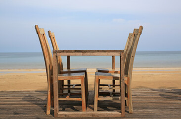 Empty wood table and chairs at restaurants near the beach.