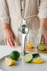 The girl makes lemonade from lemon and lime. The production process of homemade lemon. Girl's hands