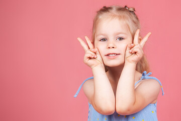a little cheerful girl on a pink background