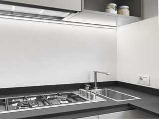 Close-up of a steel sink and gas hob in a modern kitchen