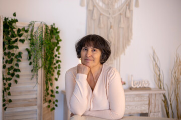 Elderly woman, posing at home, sitting on sofa or bed