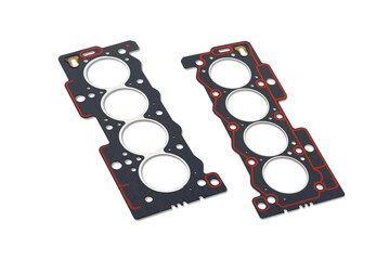 Two cylinder head gaskets with red sealant on a white background. View on two sides. A small shadow.