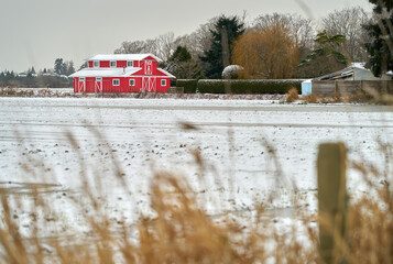 Red Barn Winter Snow. A scenic bright, red, barn behind a snowcovered field.

