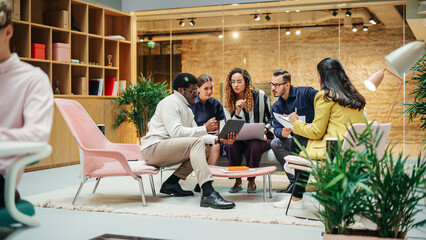 Multiethnic Young Group of People Brainstorming Together in a Meeting Room at the Office. Black Male E-commerce Coordinator Pitching His Ideas To Startup Management Board Members Using Tablet - obrazy, fototapety, plakaty