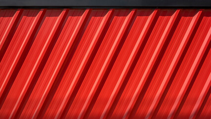 Sunlight and shadow on diagonal pattern of red Corrugated steel fence wall with black edge