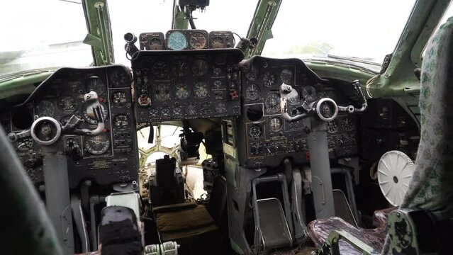 Control panel in cabin of old aircraft with command texts in russian language. Pilots' seats empty. Indicators of latitude altitude. Military aeroplane. No logo and trademarks