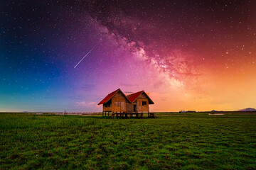 Landscape image of milky way over the abandoned twin house near Chalerm Phra Kiat road in Thale Noi, Phatthalung, Thailand
