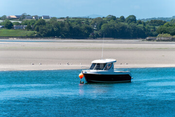 Fototapeta na wymiar boat is anchored in the bay at low tide, a seaside landscape. A boat in shallow water on a sunny day. Irish seascape, boat on sea.