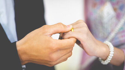 Obraz premium A groom puts a wedding ring on the bride finger