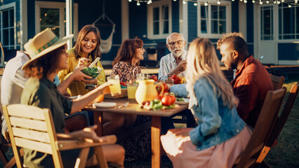 Parents, Children and Friends Gathered at a Barbecue Dinner Table Outside a Beautiful Home. Multicultural Old and Young People Have Fun, Eat and Drink. Garden Party Celebration in a Backyard.