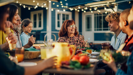 Parents, Children, Relatives and Friends Having an Open Air Barbecue Dinner in Their Backyard. Old and Young People Talk, Chat, Have Fun, Eat and Drink. Garden Party Celebration in a Backyard.