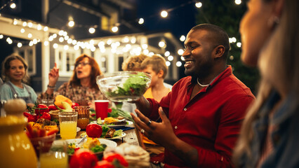 Big Family Garden Barbecue Party Celebration, Gathered Together at a Table with Relatives and Friends. Young and Senior People are Eating, Drinking, Passing Dishes, Joking and Having Fun.