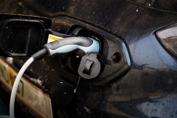 An electric vehicle being charged in a charging station