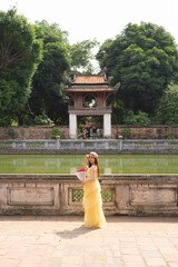 Portrait of Asian Vietnamese woman girl in local temple traveling in Hanoi urban city town, Vietnam. People lifestyle.
