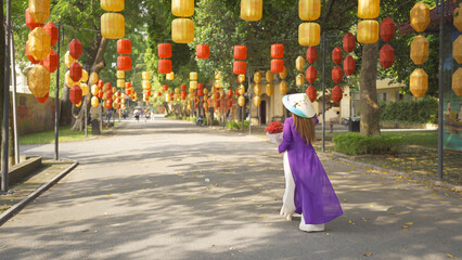 Naklejka premium Portrait of Asian Vietnamese woman girl in local temple with light lanterns festival traveling in Hanoi urban city town, Vietnam. People lifestyle.