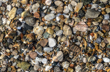 Abstract pebble background. Pebble texture in sea water. Stone background. Sea pebble beach. Beautiful nature. copy space