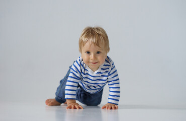 Little, happy and smiling cute baby in the studio. Portrait of a one year old baby. The concept of happiness.