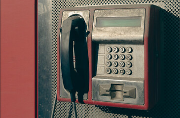 Street dusty payphone close-up, obsolete street telephone set.