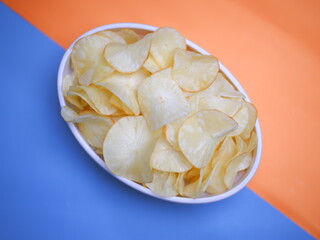 Keripik singkong, Cassava chips in a white bowl on a bright two-tone background