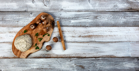 Fresh dough, mushrooms and herbs for making homemade pizza on white wood table
