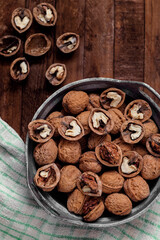 Bowl with dried organic walnuts on a wooden background.