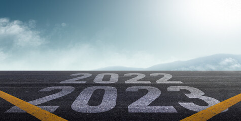 happy new year 2023. road to 2023 goals concept. text 2023 and goals written on the road with sunrise background.