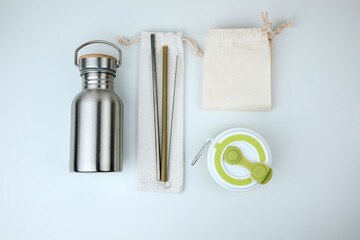 Set of devices for cold and hot drinks. Zero waste concept. A tin bottle for water and a folding mug for coffee, tea, reusable straws. Flat lay