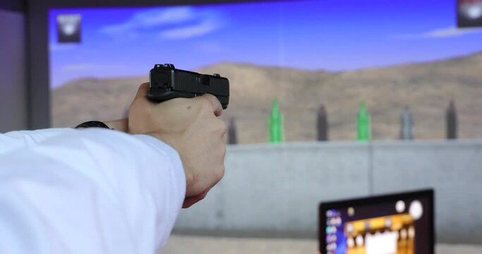 A man training with a gun on a digital shooting simulator.
