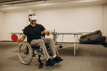 A disabled man plays digital ping pong using virtual reality technology. Table tennis concept