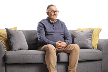 Fototapeta premium Smiling mature man sitting on a sofa