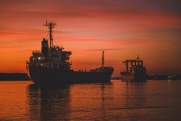 Cargo ship on the coast at sunset. Logistics and transportation of International Cargo ship. Freight Transportation,