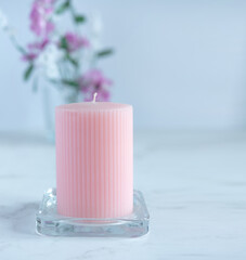unlit pink candle on floral background