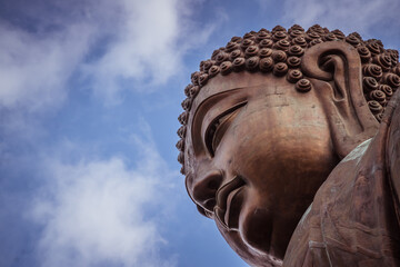 Close up of the big bronze Buddha statue called Tian Tan Buddha  at Po Lin Monastery Ngong Ping in Lantau Island famous tourist destination in Hong Kong China 
