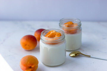 Homemade yogurt with juicy apricots. Yogurt on a white table