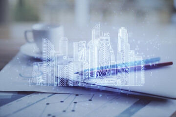 Desktop computer background in office and big town buildings hologram drawing. Double exposure. Smart city concept.