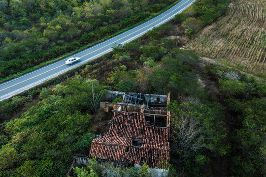 Aerial view of a vehicle driving a countryside road at sunset in Quixeramobim, Cear&aacute;, Brazil.