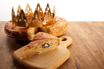 King cake or galette des rois in French. Epiphany pie with golden paper crown and little ceramic...