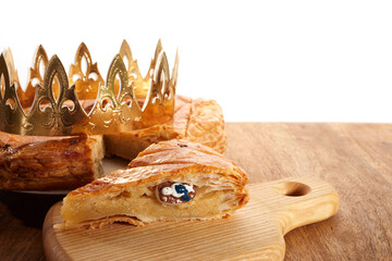 King cake or galette des rois in French. Epiphany pie with golden paper crown and little ceramic...