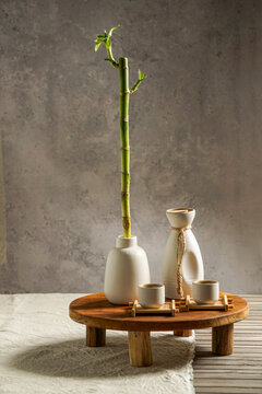 Japanese sake still life with a sprig of bamboo, light linen background, Asian ceremony