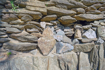The texture of the masonry wall of natural stone. Detail of a stone wall with different size of rocks.