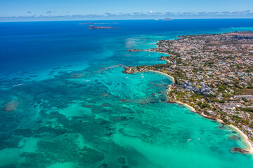 Grand Baie, Mauritius - aerial landscape view of Grand Bay, the infrastructure and buildings along the coastline, many boats on water and Gunner's Quoin in background 