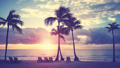 Caribbean tropical beach with coconut palm trees silhouettes at sunset, color toning applied,...