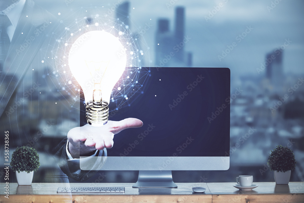 Poster Computer on desktop in office with bulb icon hologram. Multi exposure. Concept of idea.