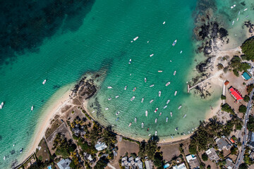 Cap Malheureux, Mauritius - vertical aerial landscape view of Bay, the infrastructure and buildings along the coastline, the Notre-Dame Auxiliatrice de Cap Malheureux and boats on water