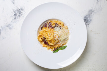 top view carbonara pasta with bacon, cream and cheese on a white plate in a restaurant