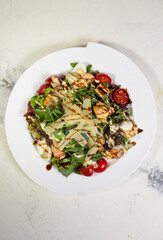 top view salad with shrimp and tomatoes, cheese and herbs on a plate in a restaurant