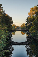 Fototapeta premium An old bridge over a canal with autumn forest left and right