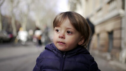 Baby toddler walking in city sidewalk outside during winter