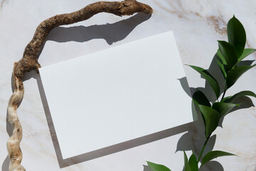empty blank card, wood and flowers white background. Elegant modern mockup flat lay. Copy space.