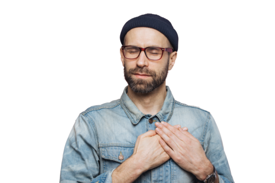 Pleased bearded man with closed eyes, keeps hands on chest, dressed in fashionable clothes, isolated over pink studio background. Middle aged male with shut eyes, expresses his love and sympathy